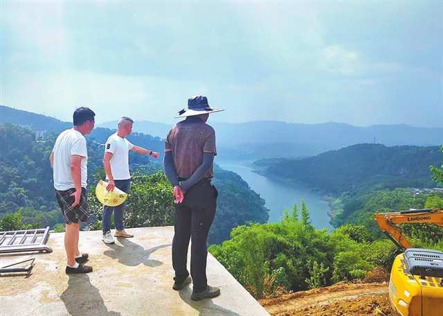 李江涛（中）给客商介绍桃花山村资源环境。