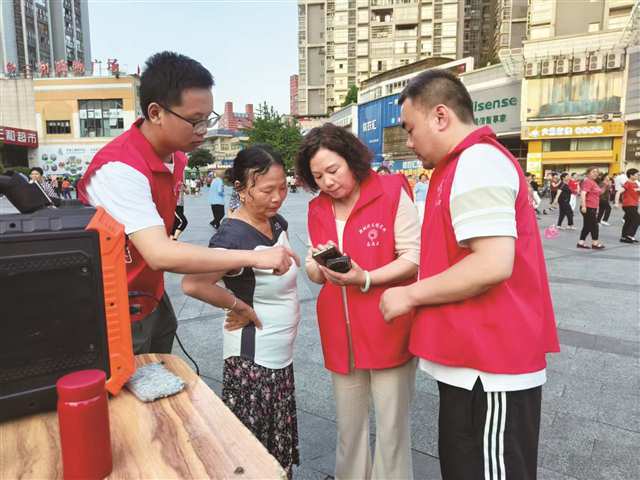 任靜（左三）指導(dǎo)居民如何查詢社保。（圖片由開(kāi)州區(qū)漢豐街道提供）