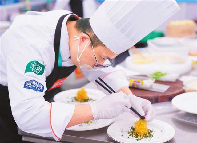 在2025世界川菜烹饪技能大赛上,参赛选手在进行摆盘。(受访单位供图)