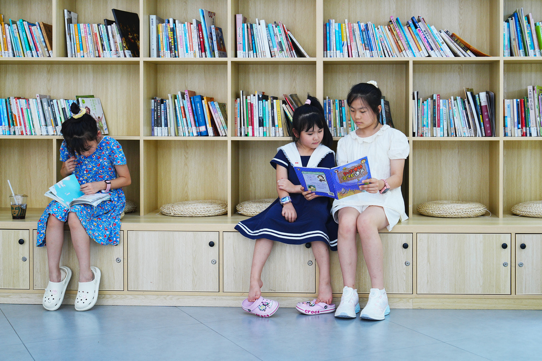 7月27日，在北碚区青少年活动中心，参加假期公益托管的孩子们正在阅读重庆新华出版集团团委赠送的课外书籍。（摄影：秦廷富）