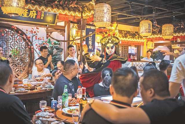 食客在杨记隆府店内欣赏川剧变脸表演。(受访单位供图)